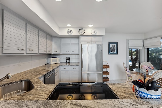 kitchen featuring stone counters, white cabinets, sink, tasteful backsplash, and stainless steel appliances