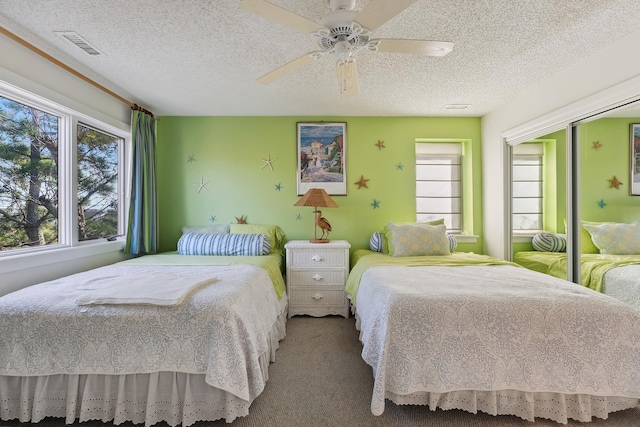 bedroom with carpet flooring, a textured ceiling, and ceiling fan