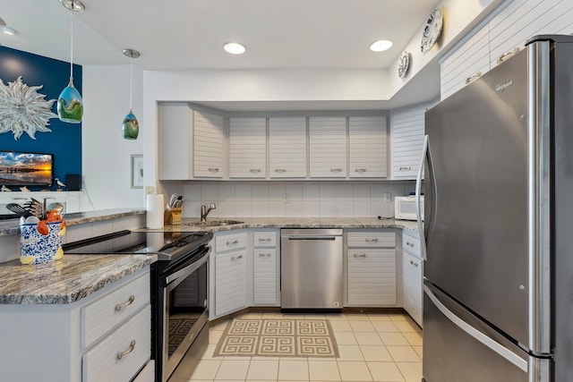 kitchen with white cabinetry, sink, decorative light fixtures, decorative backsplash, and appliances with stainless steel finishes