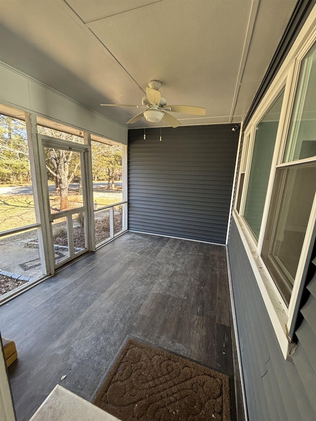 unfurnished sunroom featuring a ceiling fan