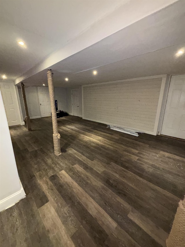 finished basement featuring brick wall, baseboards, wood finished floors, and recessed lighting