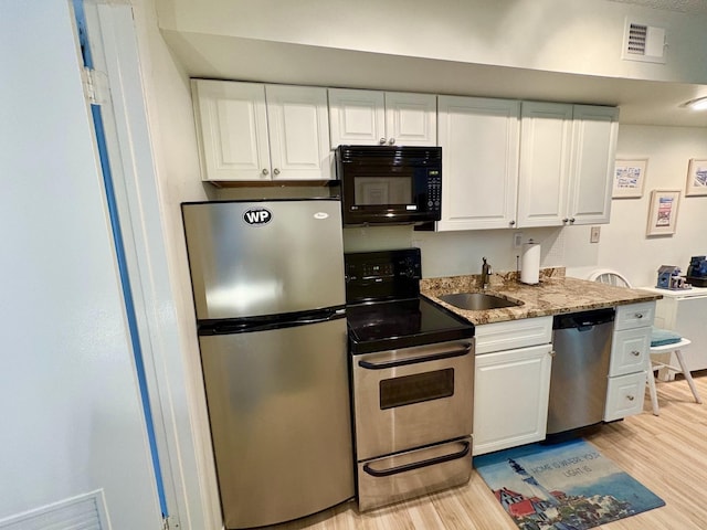 875 Plymouth Pl Unit 33, Ocean City, NJ 08226 - kitchen with appliances with stainless steel finishes, a sink, light wood finished floors, white cabinetry, and light stone countertops