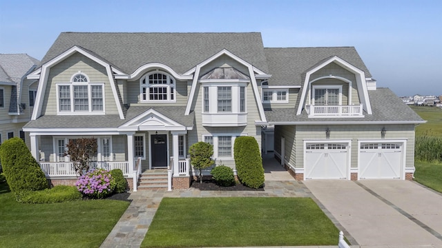 9 Seabreeze Ln, Avalon Manor, NJ 08202 - shingle-style home with driveway, covered porch, a front yard, a shingled roof, and an attached garage