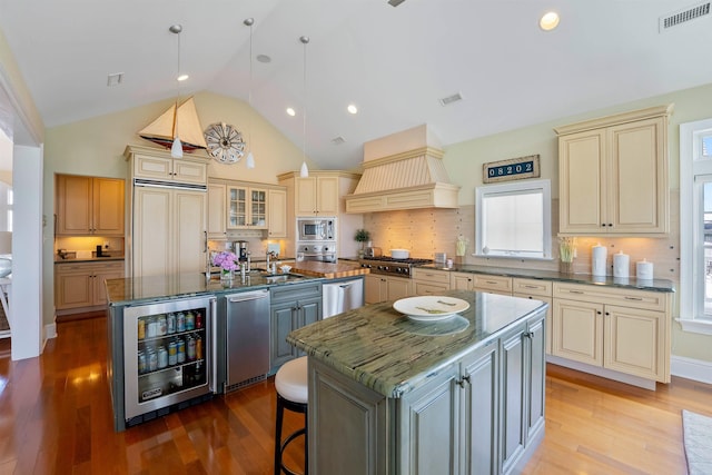 9 Seabreeze Ln, Avalon Manor, NJ 08202 - kitchen featuring cream cabinetry, a kitchen island with sink, beverage cooler, built in appliances, and premium range hood