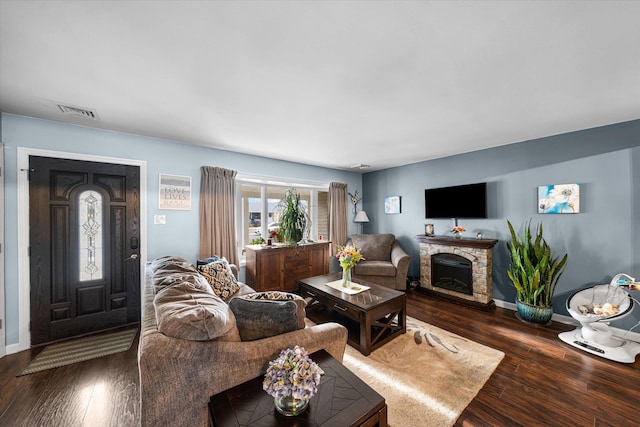 living room featuring dark hardwood / wood-style flooring and a fireplace