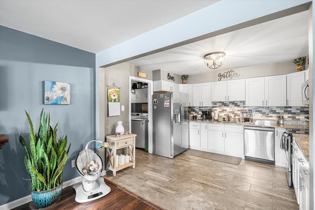 kitchen with light stone countertops, white cabinetry, appliances with stainless steel finishes, and decorative backsplash