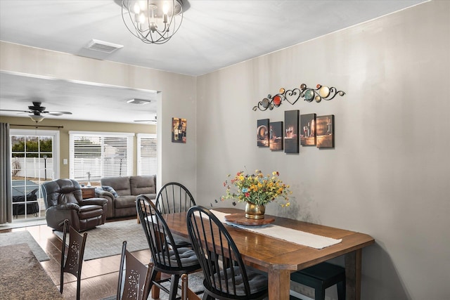 dining room with ceiling fan with notable chandelier