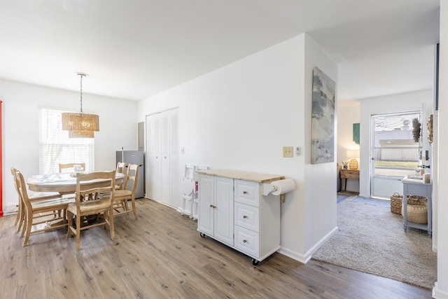 dining room with light wood-style flooring and baseboards