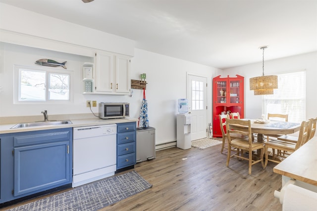 kitchen featuring light wood finished floors, blue cabinetry, white dishwasher, a sink, and stainless steel microwave