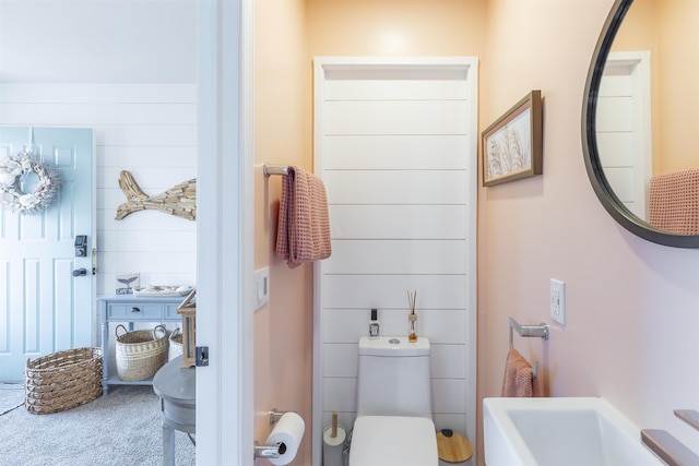 half bath with wooden walls and toilet