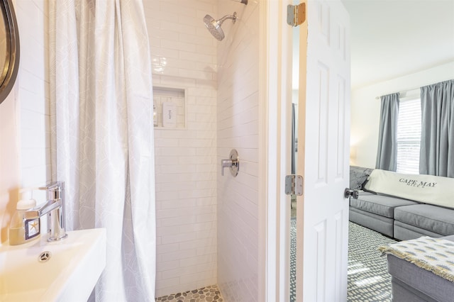 bathroom with a stall shower and a sink