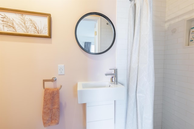 full bathroom with a tile shower and a sink