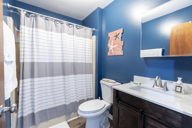 full bathroom featuring shower / tub combo with curtain, toilet, wood finished floors, and vanity