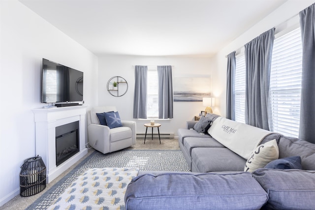 living area with a glass covered fireplace, a baseboard heating unit, baseboards, and carpet floors