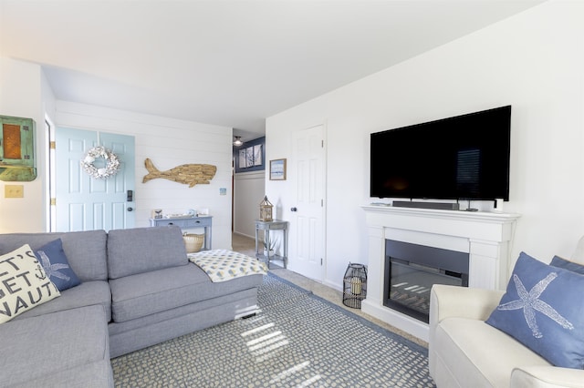 living room featuring a glass covered fireplace and carpet flooring