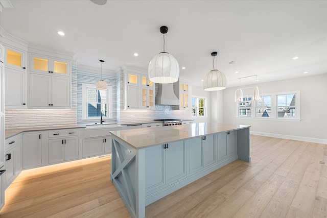 kitchen with pendant lighting, white cabinetry, and a kitchen island