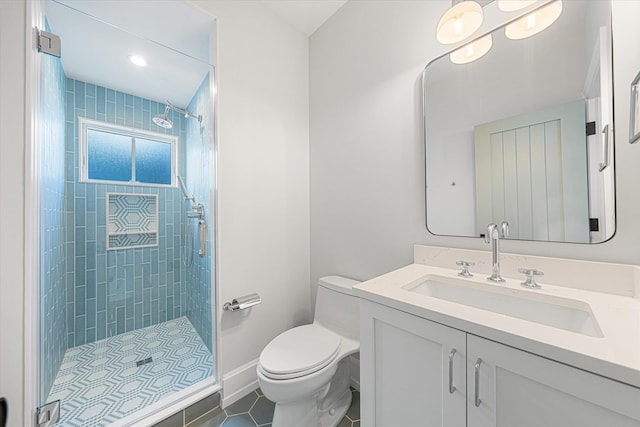 bathroom featuring tile patterned floors, vanity, toilet, and a tile shower