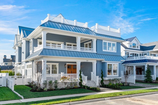 view of front of home featuring a balcony, covered porch, and a front yard