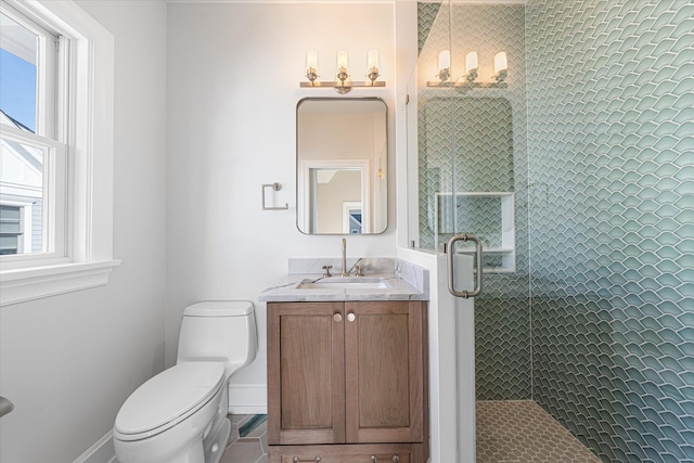 bathroom featuring plenty of natural light, toilet, a shower with door, and vanity