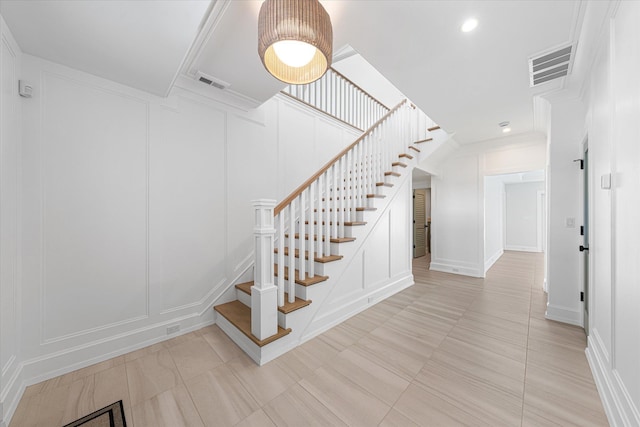 stairway featuring ornamental molding