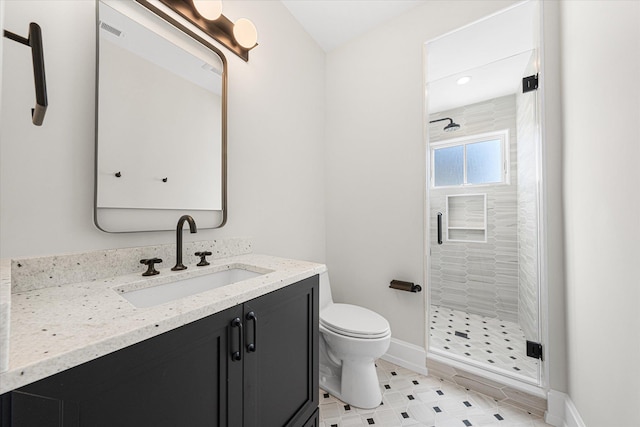 bathroom with a shower with door, vanity, and toilet