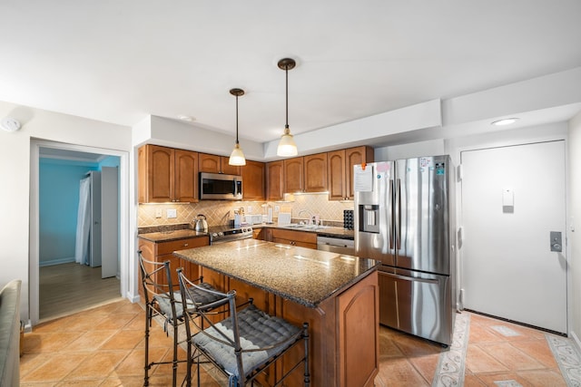 66 E 20th St Unit 108, Avalon, NJ 08202 - kitchen featuring appliances with stainless steel finishes, tasteful backsplash, dark stone countertops, brown cabinets, and recessed lighting