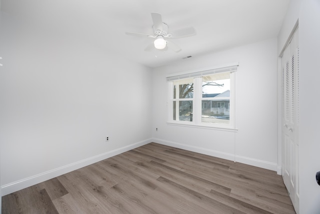 unfurnished bedroom featuring ceiling fan, light hardwood / wood-style floors, and a closet