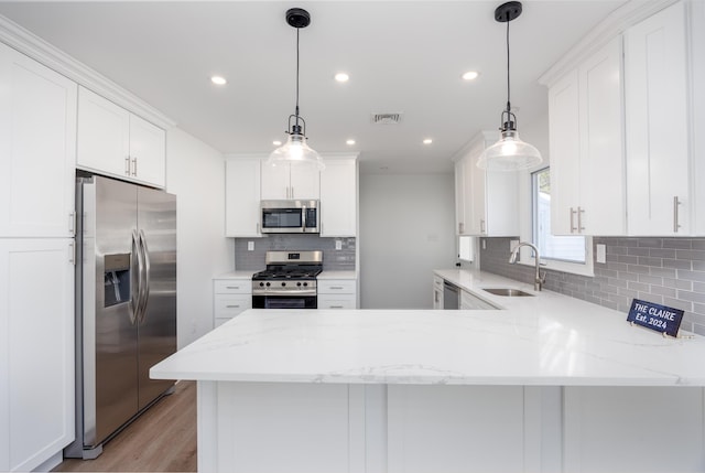 kitchen featuring pendant lighting, sink, stainless steel appliances, and kitchen peninsula