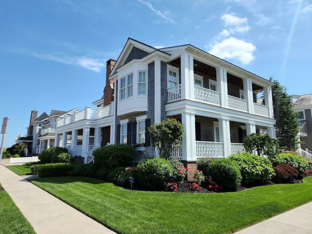 8700 1st Ave, Stone Harbor, NJ 08247 - view of property exterior with a balcony, a chimney, a yard, and a porch