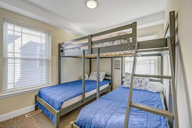 bedroom with visible vents, baseboards, and multiple windows