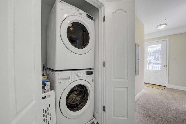 laundry room with laundry area, baseboards, carpet flooring, and stacked washer and clothes dryer