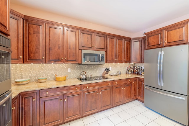 kitchen featuring tasteful backsplash, light stone countertops, light tile patterned flooring, and stainless steel appliances