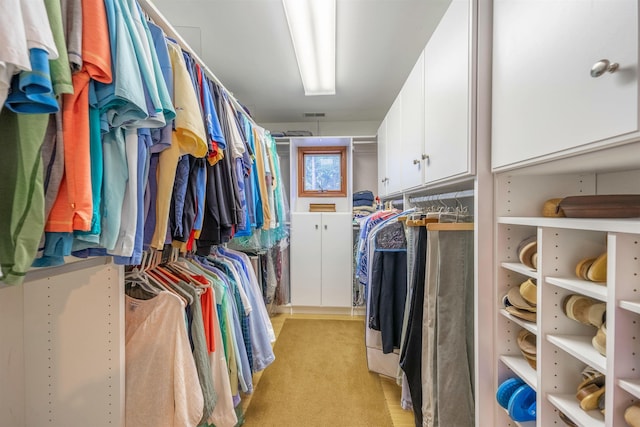 walk in closet featuring light colored carpet