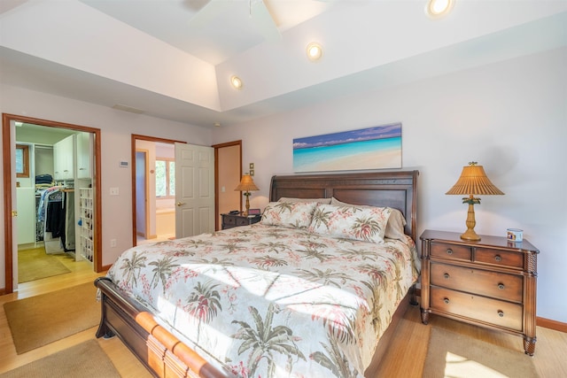 bedroom with a walk in closet, ensuite bath, ceiling fan, light hardwood / wood-style flooring, and a closet