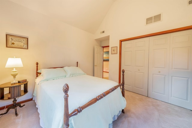 bedroom featuring a closet, high vaulted ceiling, and light colored carpet