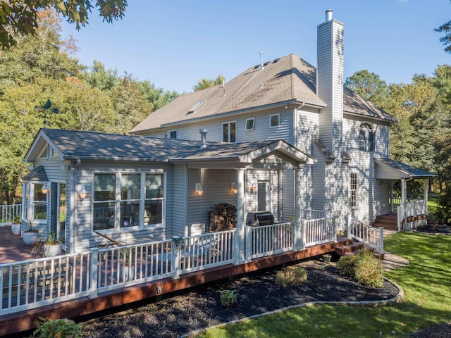 rear view of house featuring a yard and a wooden deck