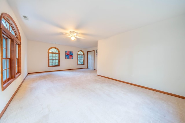 empty room with ceiling fan and light carpet