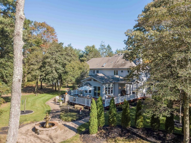 back of property featuring a yard and a wooden deck