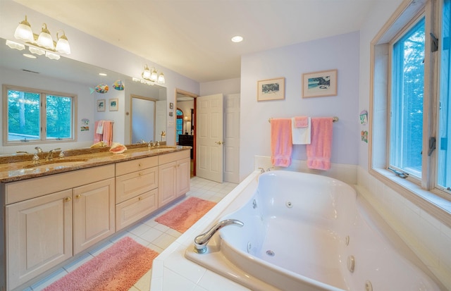 bathroom with tile patterned floors, a relaxing tiled tub, and vanity