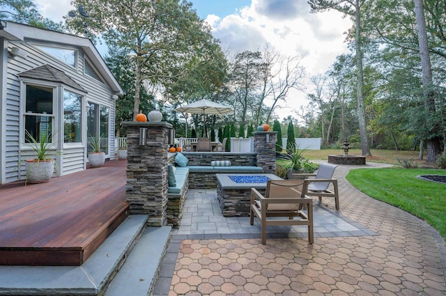 view of patio with a deck and an outdoor living space with a fire pit