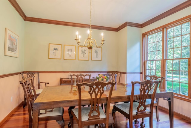 dining space with hardwood / wood-style floors, a notable chandelier, and crown molding