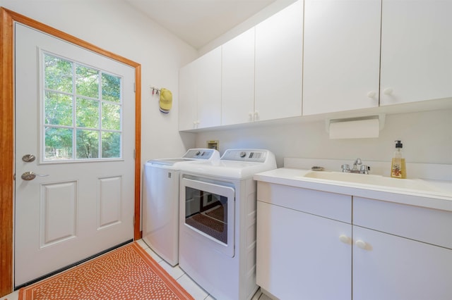 laundry area featuring cabinets, light tile patterned floors, washer and dryer, and sink