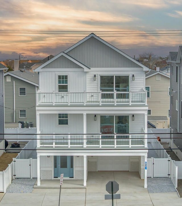 coastal home featuring a gate, a fenced backyard, and a balcony