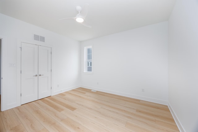 unfurnished room with light wood-style floors, baseboards, visible vents, and ceiling fan