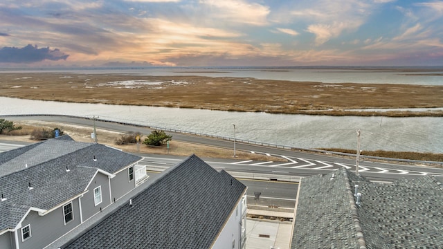 aerial view at dusk featuring a water view