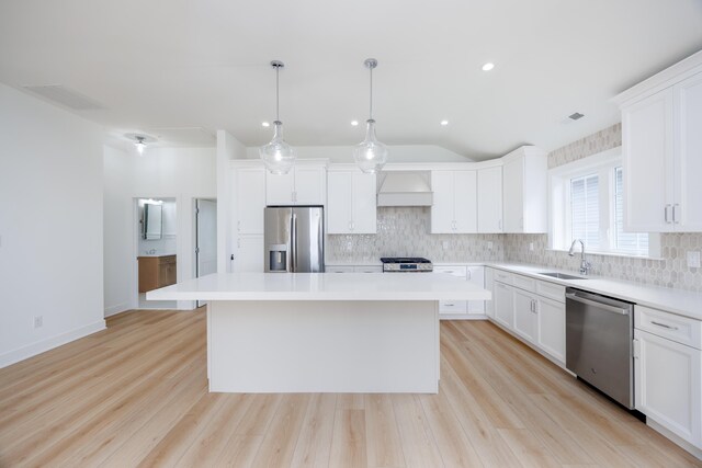 kitchen featuring white cabinets, a kitchen island, vaulted ceiling, and custom exhaust hood