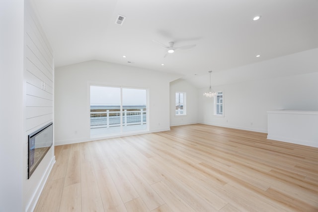 unfurnished living room featuring lofted ceiling, light wood finished floors, a fireplace, and visible vents