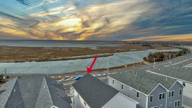 aerial view at dusk featuring a water view