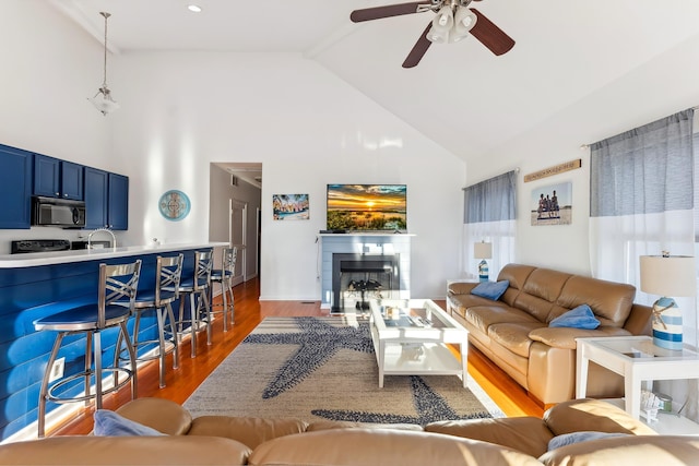 living room with beamed ceiling, ceiling fan, sink, dark hardwood / wood-style floors, and high vaulted ceiling