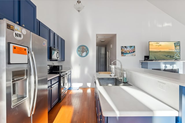 kitchen featuring blue cabinetry, sink, a high ceiling, light hardwood / wood-style flooring, and stainless steel appliances